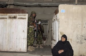 File - An Iraqi Army 3rd Battalion, 2nd Brigade, 6th Division- Wareagles- soldier pulls security during a raid in Sadr City, Baghad, Iraq, Sept. 10, 2005