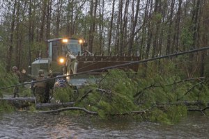 File - U.S. Marines with Marine Wing Support Squadron 272 cut down a tree on Marine Corps Air Station New River, N.C., Sept. 14, 2018. Hurricane Florence is expected to impact Marine Corps Base Camp Lejeune and MCAS New River with expected periods of strong winds, heavy rains, flooding of urban and low lying areas, potential flash floods and coastal storm surges.