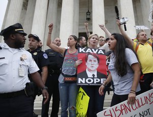 Police move activists as they protest on the steps of the Supreme Court after the confirmation vote of Supreme Court nominee Brett Kavanaugh, on Capitol Hill, Saturday, Oct. 6, 2018 in Washington.