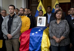 Opposition leader Henrique Capriles, left, and lawmaker Dinorah Figuera, stand vigil around the flag-draped casket containing the remains of opposition activist Fernando Alban, during a solemn ceremony at the National Assembly headquarters, in Caracas, Venezuela, Tuesday, Oct. 9, 2018.