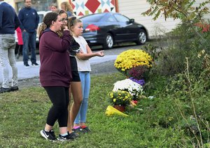 Friends of victims that died in a fatal limousine crash comfort each other after placing flowers were 20 people died at the intersection on Route 30 and 30 A on Oct. 6, 2018, Saturday Oct. 7, 2018, in Schoharie, N.Y.