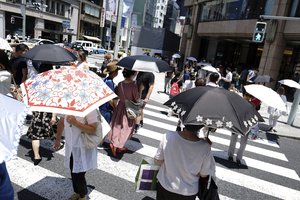 A deadly heat wave in Japan. People under parasols walk on a pedestrian crossing in Tokyo Friday, July 20, 2018.