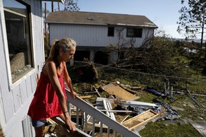 Monica Jones looks out over the debris littering her yard after riding out hurricane Michael in her home in Callaway, Fla., Thursday, Oct. 11, 2018.