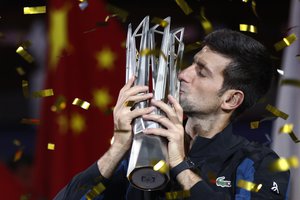 Novak Djokovic of Serbia kisses his trophy after defeating Borna Coric of Croatia in their men's singles final match to win the Shanghai Masters tennis tournament at Qizhong Forest Sports City Tennis Center in Shanghai, China, Sunday, Oct. 14, 2018.