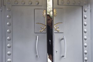 A security personnel looks out from the entrance of the Saudi Arabia's consulate in Istanbul, Sunday, Oct. 14, 2018. Writer Jamal Khashoggi, vanished after he walked into the consulate on Oct. 2.