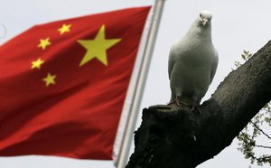 A dove rests at tree near a Chinese flag at a park on Monday April 1, 2013 in Shanghai, China