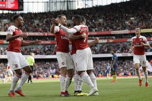 Arsenal's Alexandre Lacazette celebrates his side's second goal with his teammates after his shot deflected by West Ham's Issa Diop scoring own goal during the English Premier League soccer match between Arsenal and West Ham United at the Emirates Stadium in London, Saturday Aug. 25, 2018