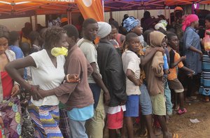 In this photo taken on Saturday, Aug. 19, 2017, people displaced by recent heavy floods and mudslides wait for food ration in Freetown, Sierra Leone. It's particularly difficult in an impoverished West African country where an Ebola outbreak decimated many families just two years ago. Aid groups say they are on alert for child traffickers.