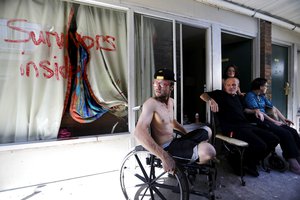 Wes Allen, Jr., from left, sits with his father Wes Allen, Sr., sister Alison, and mother Vicki outside their room at a damaged motel Tuesday, Oct. 16, 2018, in Panama City, Fla., where many residents continue to live in the aftermath of Hurricane Michael.