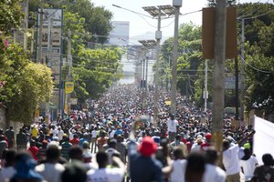 Protesters walk along the main street of Delmas, demanding to know how Petro Caribe funds have been used by the current and past administrations, in Port-au-Prince, Haiti, Wednesday, Oct. 17, 2018.