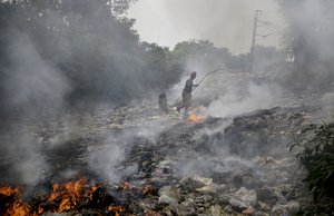 A heap of garbage is set on fire as an Indian man walks past in New Delhi, India, Tuesday, Oct. 16, 2018. Since being identified as one of the world’s most polluted cities, the Indian capital has struggled to clean its air.