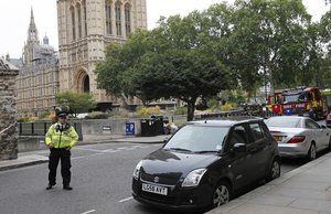 File - A police officer stands guard outside the Houses of Parliament, in London, Tuesday, Aug. 14, 2018.