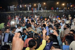 An angry crowd shouts slogans at the site of a train accident in Amritsar, India, Friday, Oct. 19, 2018.