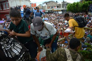 duran migrants climb a border fence, in Tecun Uman, Guatemala, Friday, Oct. 19, 2018.