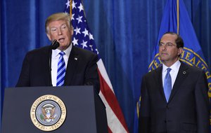 President Donald Trump, left, standing with Health and Human Services Secretary Alex Azar, right, talks about drug prices during a visit to the Department of Health and Human Services in Washington, Thursday, Oct. 25, 2018.