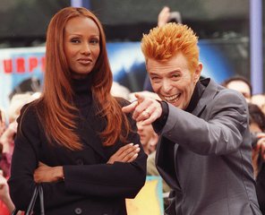 File - Rock and roll legend David Bowie gestures to the crowd before receiving the 2,083rd star on the Hollywood Walk of Fame in the Hollywood section of Los Angeles, Wednesday, Feb. 12, 1997, as his wife, supermodel Iman, looks on.