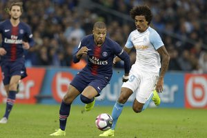 PSG's Kylian Mbappe, left, and Marseille's Gustavo Luiz challenge for the ball during the French League One soccer match between Paris-Saint-Germain and Marseille at the Velodrome Stadium in Marseille, France, Sunday, Oct. 28, 2018.