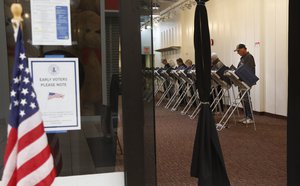 Randy Wick, right, 68, fills in his midterm election ballot at an early voting poll at a mall in Bloomingdale, Ill., on Thursday, Oct. 25, 2018.