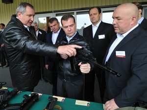 File - Russian Prime Minister Dmitry Medvedev, centre, listens to deputy premier Dmitry Rogozin, as he visits a factory, producing weapons components in Klimovsk outside Moscow on Wednesday, Oct. 3, 2012.