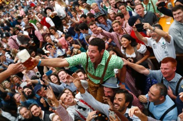 Revellers arrived early to secure spaces at the coveted long communal tables in tents, where visitors swig beer, munch ...