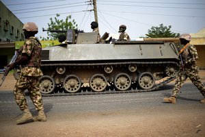 In this photo taken Monday March 9, 2015, Nigerian troops patrol in the north-eastern Nigeria city of Mubi, some 20 kms (14 miles) west of the Cameroon border.