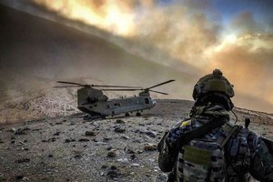 File - An airman observes an Army CH-47 Chinook helicopter at an undisclosed location in Afghanistan, Feb. 9, 2018.