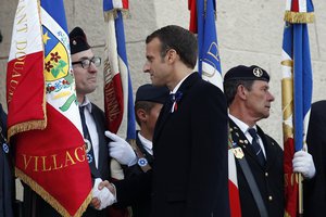 French President Emmanuel Macron greets French veterans at the cemetery by the Ossuary of Douaumont near Verdun, northeastern France, Tuesday, Nov. 6, 2018 during ceremonies marking the centenary of World War I globe.