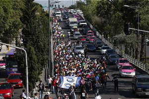 A group of Central American migrants, representing the thousands participating in a caravan trying to reach the U.S. border, undertake an hours-long march to the office of the United Nations' humans rights body in Mexico City, Thursday, Nov. 8, 2018