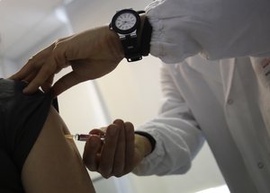 DIn this photo taken on Friday, Feb. 23, 2018 Doctor Roberto Ieraci vaccinates a woman in Rome.