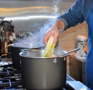 Chef Pierre ties a bunch of leeks before placing them into the pot.