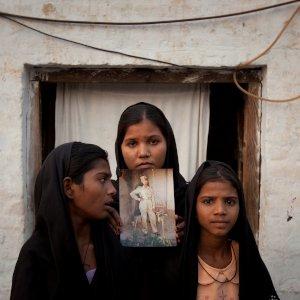 The daughters of Pakistani Christian woman Asia Bibi pose with an image of their mother while standing outside their residence in Sheikhupura located in Pakistan's Punjab Province November 13, 2010. Standing left to right is Esha, 12, Sidra, 18 and Eshum, 10. REUTERS/Adrees Latif