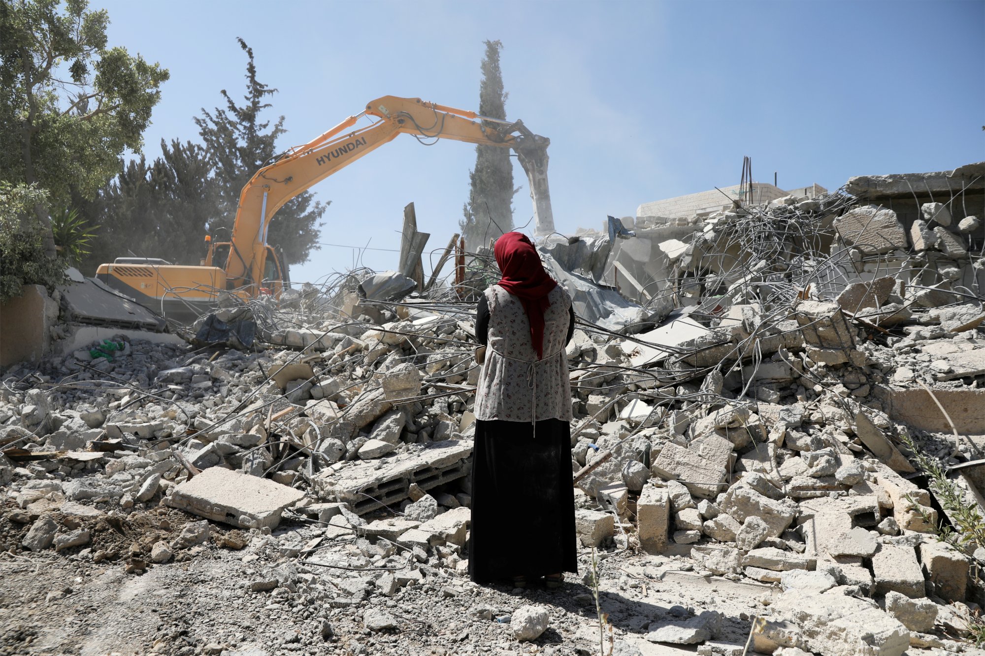 Fawzia stands on the ruins of her house, after her Palestinian ex-husband demolished the dwelling to not face the prospect of Israeli settlers moving in after he lost a land ownership case in Israeli courts, in the East Jerusalem neighbourhood of Beit Hanina, July 19, 2018. REUTERS/Ammar Awad