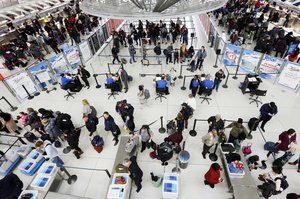 Travelers check in for flights at John F. Kennedy International Airport, Wednesday, Nov. 21, 2018, in New York.