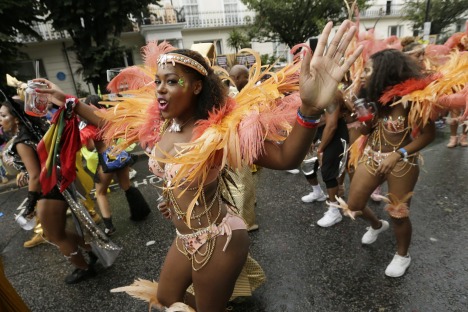 A costumed reveller performs in the Notting Hill Carnival in London, Monday, Aug. 31, 2015. Held each August Bank ...