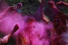 People smear colored powder on the face of a girl during celebrations marking Holi, the Hindu festival of colors, in ...