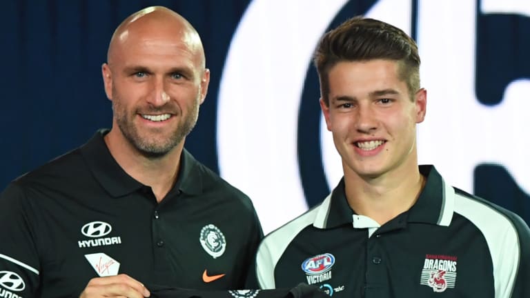 New Blue: Liam Stocker receives his Carlton jumper from Chris Judd.