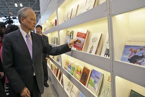 Cui Tiankai, Ambassador of China to the United States, inspects a book as he tours the China pavilion at BookExpo America, Wednesday, May 27, 2015, in New York.