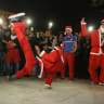 Acrobatic performers, dressed in Santa Claus costumes in Iraq.