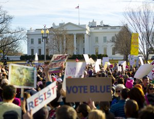 Women's March demonstrators walk past the White House in Washington, Saturday, Jan. 20, 2018.