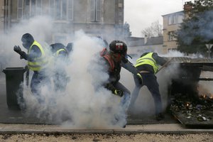 French police fires tear gas as yellow vest demonstrators set up barricades in Bourges, central France, Saturday, Jan. 12, 2019