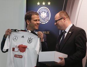 Pawel Adamowicz, a mayor of Gdansk, right, receives a shirt from theGerman Team manager Oliver Bierhoff during a press conference of Germany at the Euro 2012 soccer championship in Gdansk, Poland, Tuesday, June 5, 2012