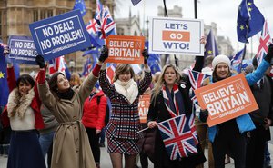 Leavers hold up signs next to pro-European demonstrators protesting opposite the Houses of Parliament in London, Tuesday, Jan. 15, 2019. Britain's Prime Minister Theresa May is struggling to win support for her Brexit deal in Parliament.