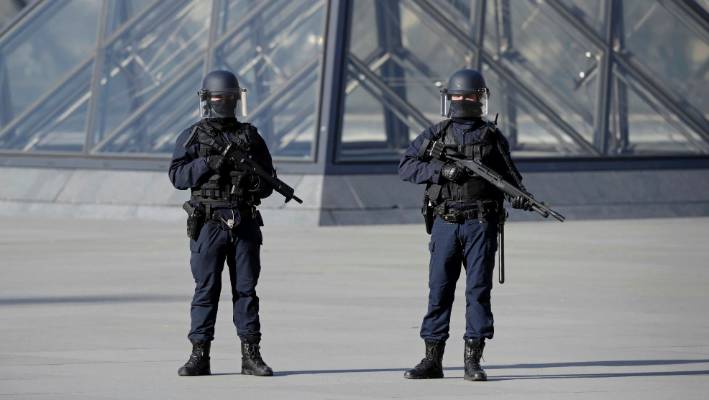 French police secure the site near the Louvre Pyramid in Paris after a French soldier shot and wounded a man armed with a knife.