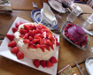 A table with a Xmas summer dessert feast: pavlova with strawberries and a berry sorbet pudding