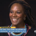 Broadly smiling black woman with long braids.