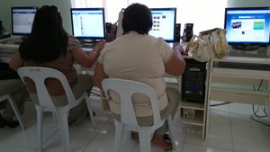 File - An obese woman at an internet cafe.