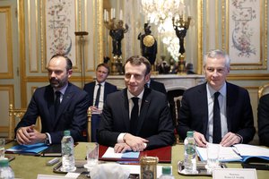 France's President Emmanuel Macron, center, France's Prime Minister Edouard Philippe, left, and France's Finance Minister Bruno Le Maire, right, attend a meeting with the representatives of the banking sector at the Elysee Palace, in Paris, Tuesday, Dec.11, 2018.