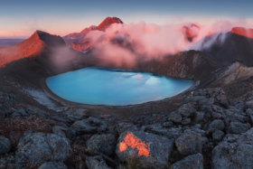 Early morning sunrise, landscape scenery of blue lake, wild mountains and huge volcano, autumn colours and golden sun rays, Tongariro National Park New Zealand North Island - Image
