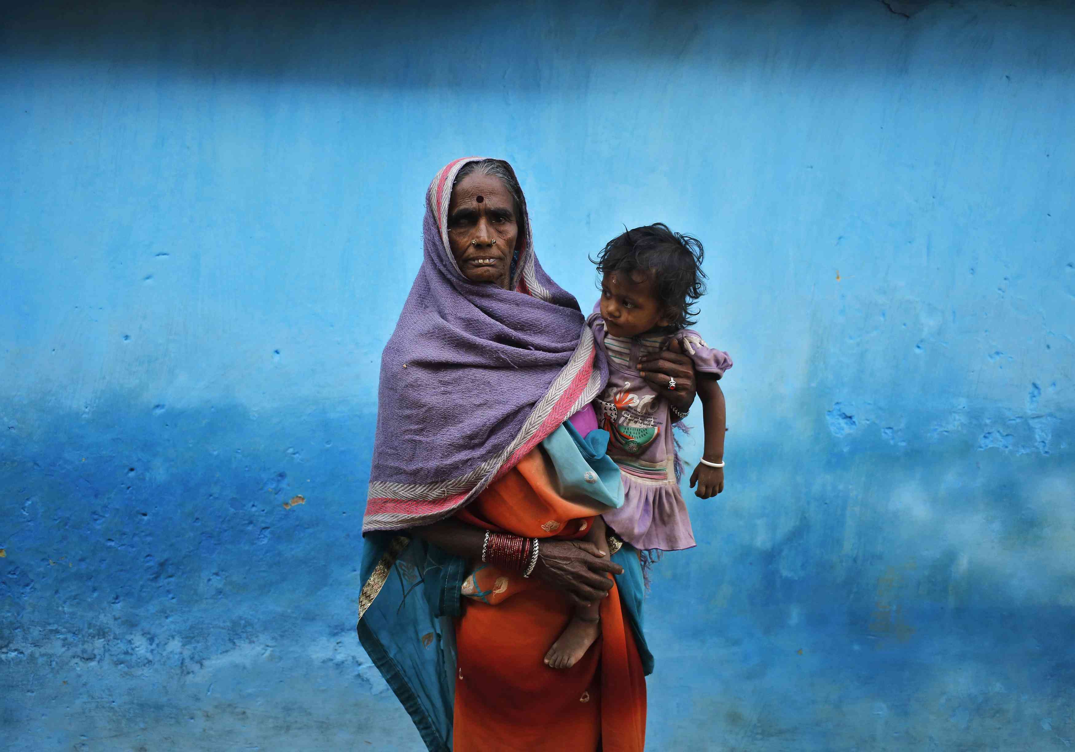 The mother of a victim who died after undergoing a sterilization surgery at a government mass sterilization camp, holds her granddaughter. Photo: Reuters