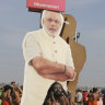 A policeman stands next to a cut out photograph of Indian Prime Minister Narendra Modi as Hindu holy men participate in a ritual after a holy dip at Sangam, the confluence of sacred rivers the Yamuna, the Ganges and the mythical Saraswat in India.